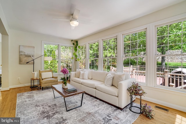 sunroom with baseboards, wood finished floors, and visible vents