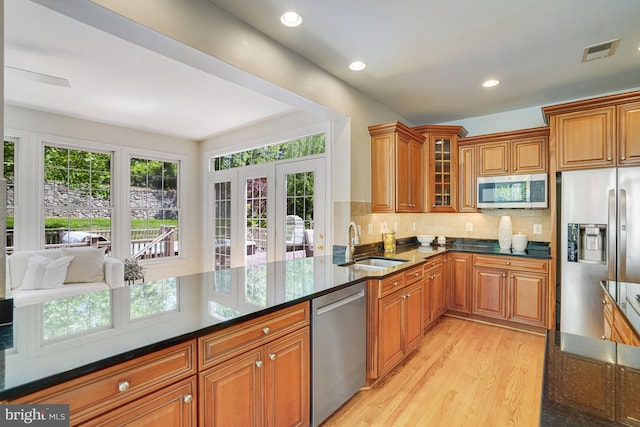 kitchen featuring a sink, stainless steel appliances, brown cabinets, and visible vents