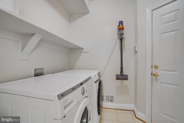 washroom with baseboards, visible vents, laundry area, and washer and dryer