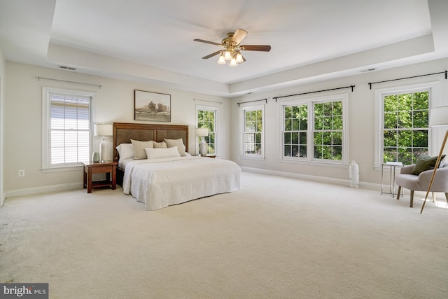bedroom featuring visible vents, carpet, a raised ceiling, and baseboards