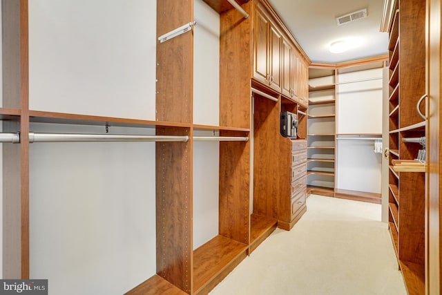 walk in closet featuring visible vents and light carpet