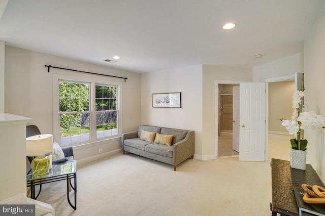 living area featuring baseboards, recessed lighting, and light carpet