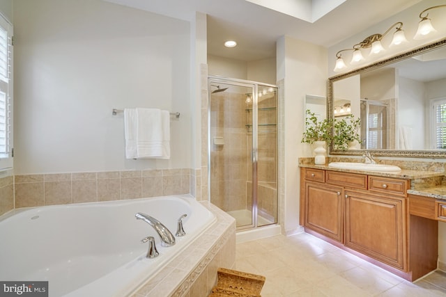 bathroom featuring vanity, a shower stall, and a garden tub