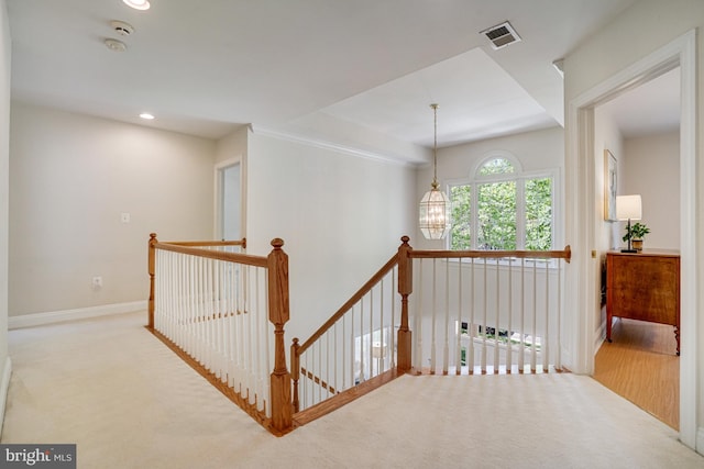 hall featuring carpet flooring, baseboards, an upstairs landing, and visible vents