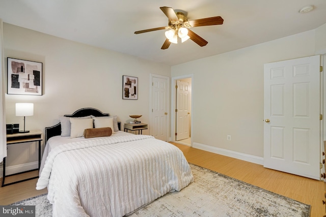 bedroom with baseboards, a ceiling fan, and light wood finished floors