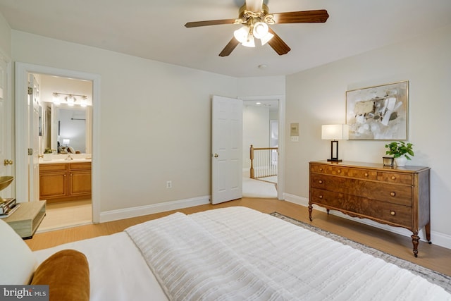 bedroom with baseboards, ceiling fan, light wood-style flooring, and connected bathroom