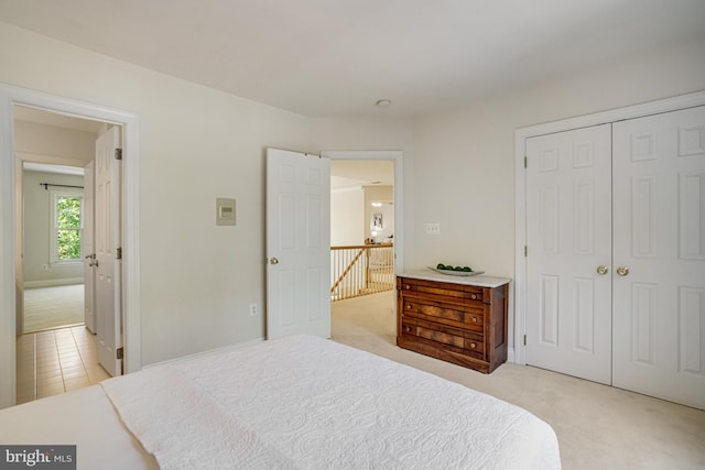 bedroom with light carpet and a closet