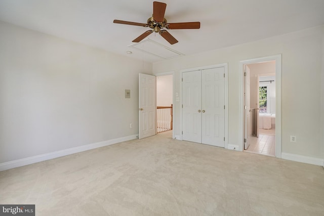 unfurnished bedroom featuring a closet, carpet floors, baseboards, and attic access
