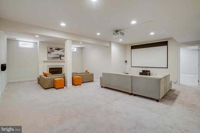 cinema featuring recessed lighting, a glass covered fireplace, and light carpet