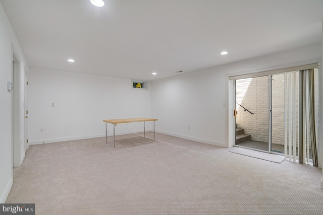 below grade area with recessed lighting, stairs, baseboards, and light carpet