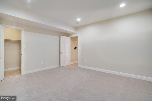unfurnished bedroom featuring light colored carpet, recessed lighting, and a spacious closet