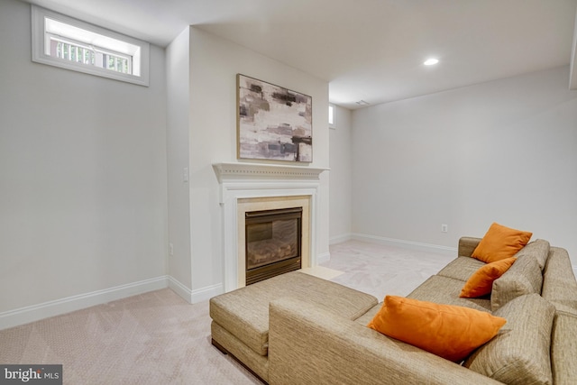 carpeted living area featuring recessed lighting, baseboards, and a fireplace with flush hearth