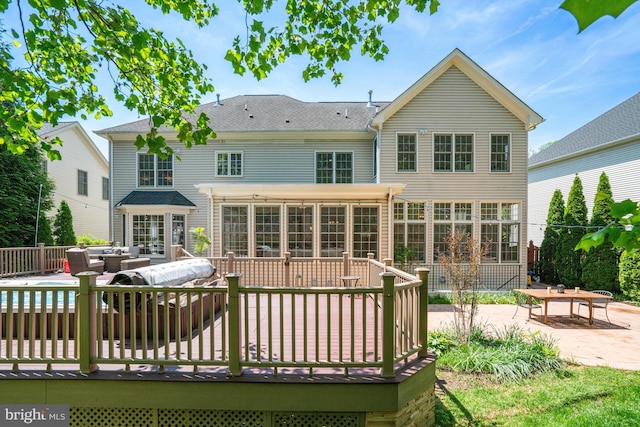 rear view of property with a deck, outdoor lounge area, a patio area, and a sunroom