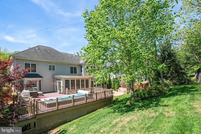 back of property with a lawn and a deck