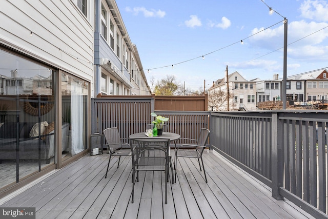 wooden terrace featuring a residential view and outdoor dining area