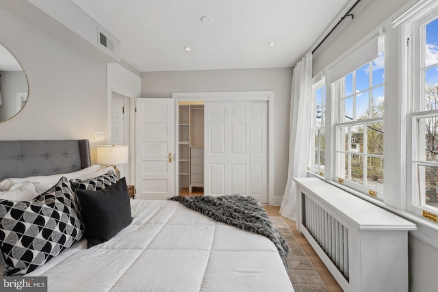 bedroom with recessed lighting, a closet, visible vents, and light wood-style floors