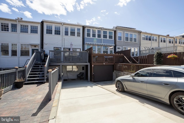 rear view of property featuring a residential view, stairs, and an attached garage