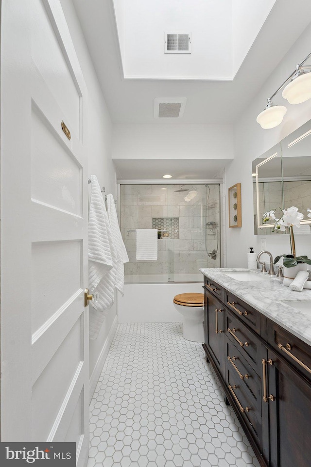 full bathroom with combined bath / shower with glass door, visible vents, toilet, and vanity