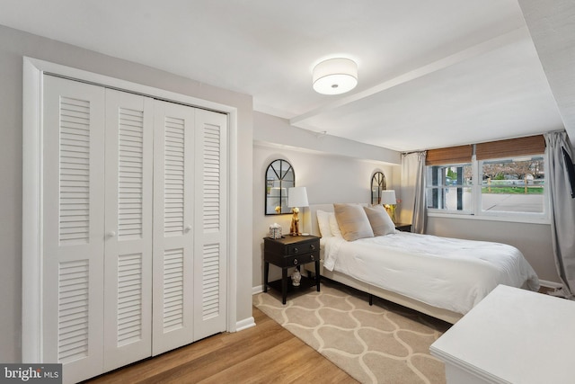bedroom featuring baseboards, wood finished floors, and a closet