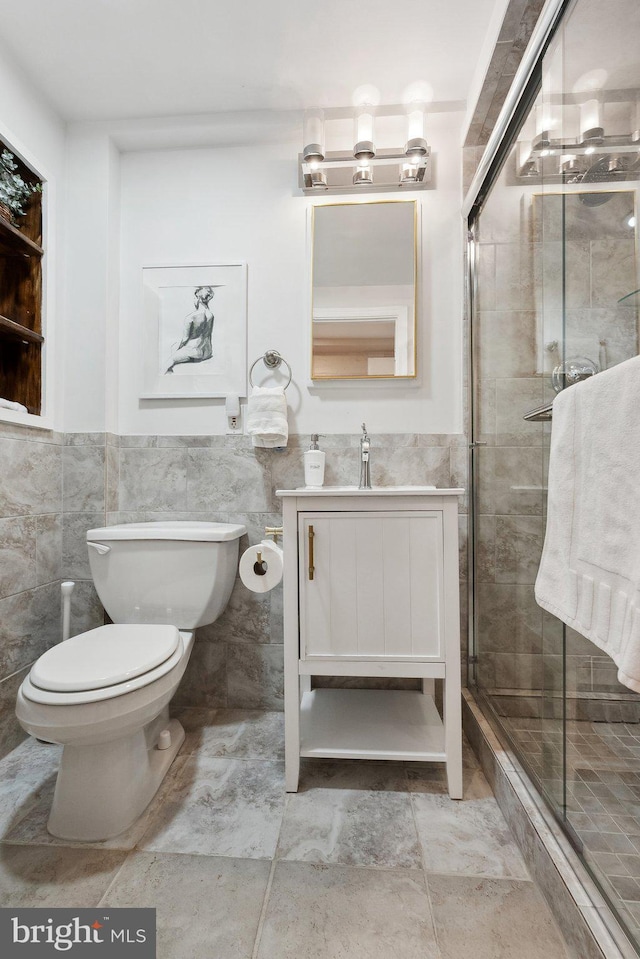 full bath featuring toilet, tile walls, a shower stall, and vanity