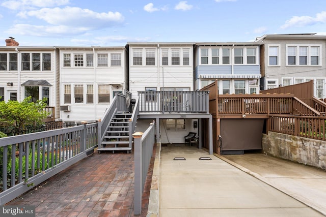 rear view of house featuring stairs and a wooden deck