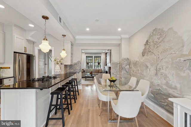 dining room featuring light wood-type flooring, crown molding, and recessed lighting