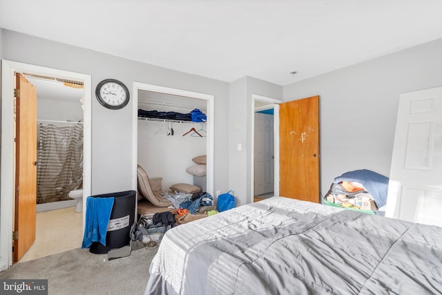 carpeted bedroom featuring ensuite bathroom and a closet