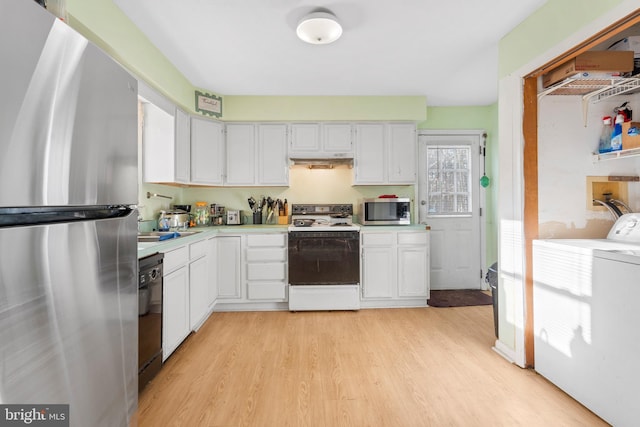 kitchen featuring white cabinets, light wood-style floors, light countertops, under cabinet range hood, and appliances with stainless steel finishes