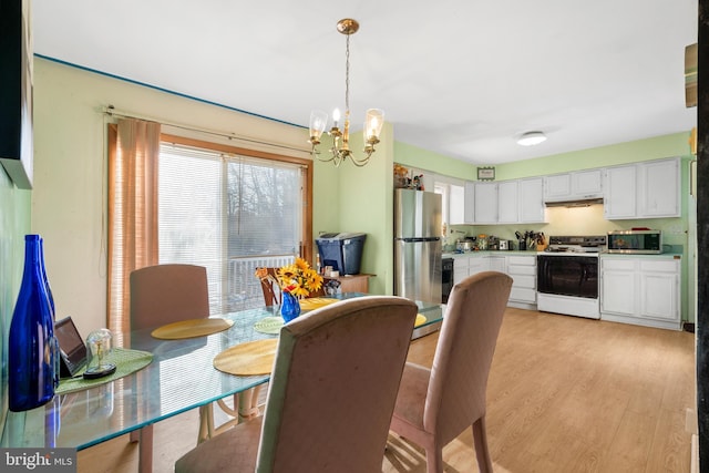 dining space featuring light wood finished floors and a chandelier