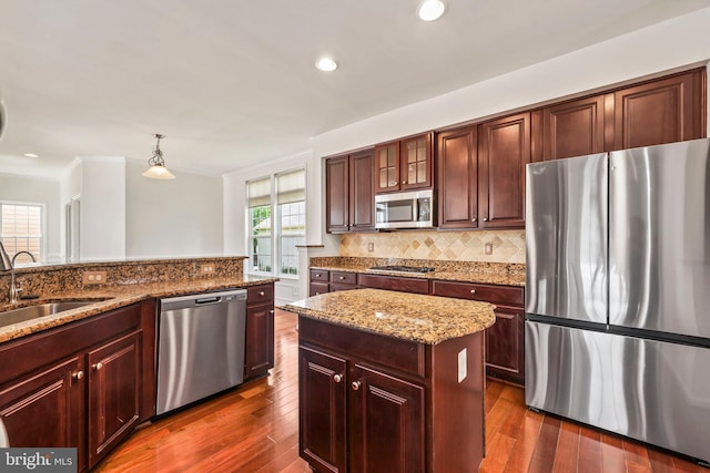 kitchen featuring a sink, decorative backsplash, appliances with stainless steel finishes, and light stone countertops