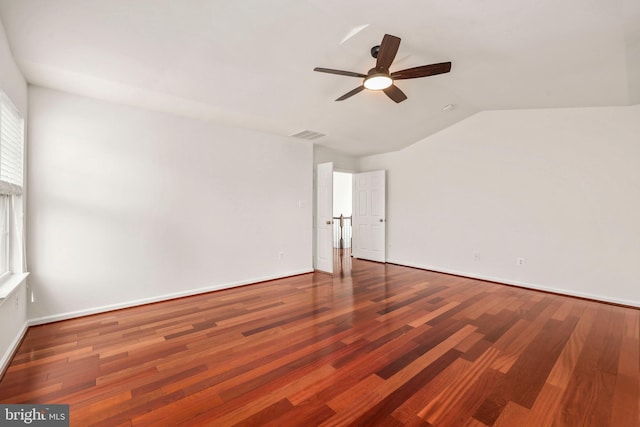 unfurnished room featuring ceiling fan, visible vents, baseboards, wood finished floors, and vaulted ceiling