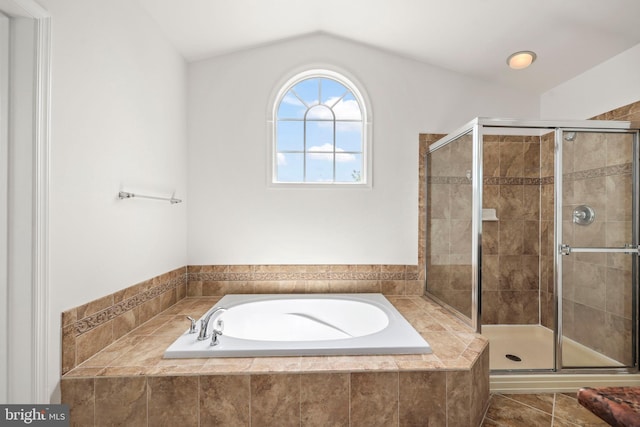 bathroom with vaulted ceiling, a shower stall, and a bath