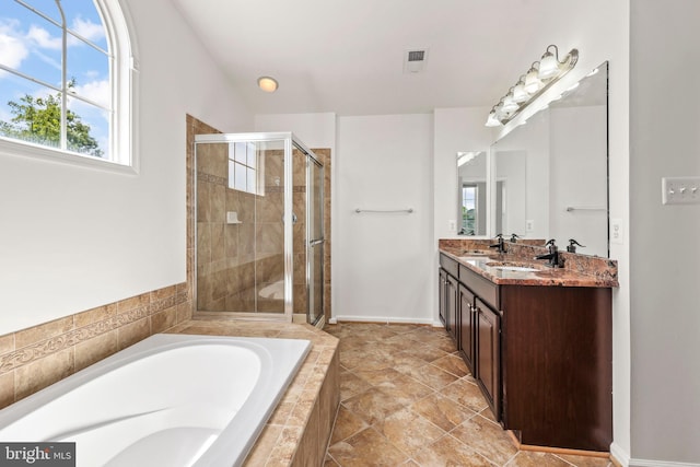 bathroom featuring a garden tub, visible vents, double vanity, a sink, and a stall shower