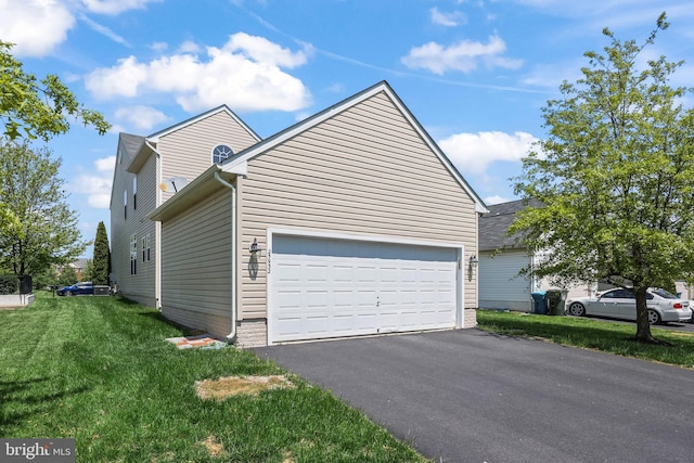 view of home's exterior featuring an attached garage, a yard, and driveway
