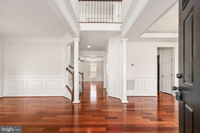 entrance foyer featuring ornate columns, visible vents, ornamental molding, and a decorative wall