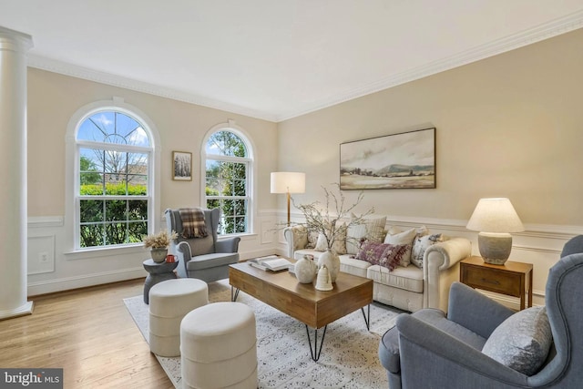 living room with decorative columns, ornamental molding, wood finished floors, and a wainscoted wall