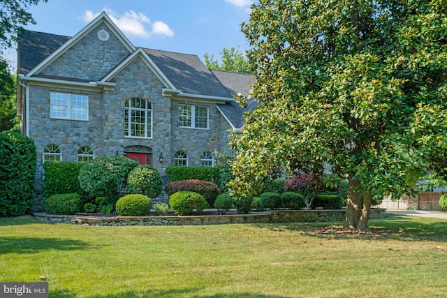 view of front of home featuring a front yard and stone siding