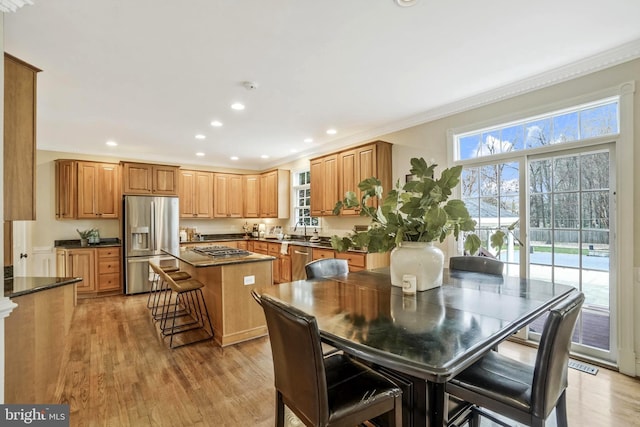dining space featuring crown molding, recessed lighting, and light wood-style floors