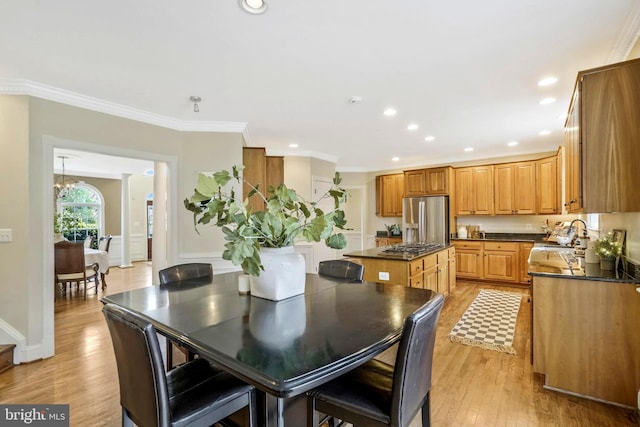 dining area featuring an inviting chandelier, recessed lighting, light wood-style floors, and crown molding