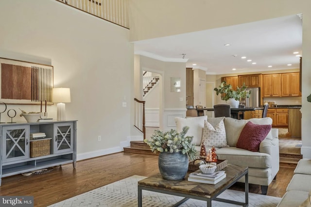 living area featuring recessed lighting, ornamental molding, stairs, and wood finished floors
