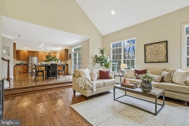 living room featuring light wood-style floors, high vaulted ceiling, and recessed lighting