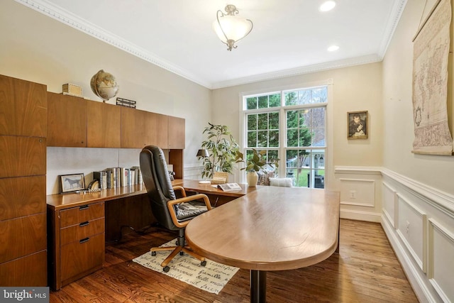home office with crown molding, a decorative wall, wood finished floors, and a wainscoted wall