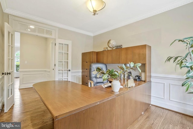 home office with french doors, ornamental molding, wainscoting, and light wood-type flooring