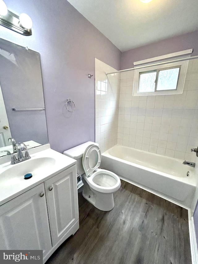 full bath with wood finished floors, toilet, vanity, and shower / bathtub combination