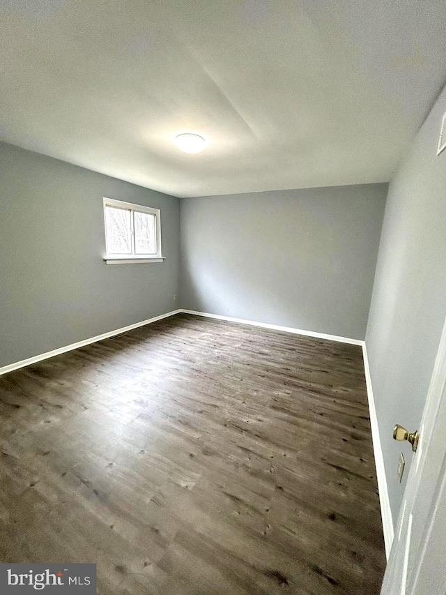 unfurnished room featuring baseboards and wood finished floors