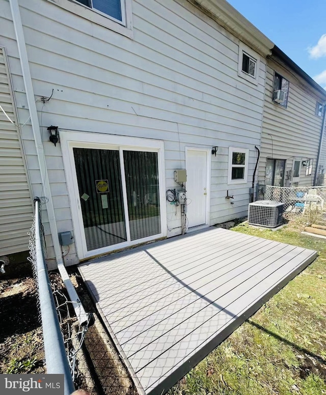 rear view of house featuring cooling unit and a wooden deck