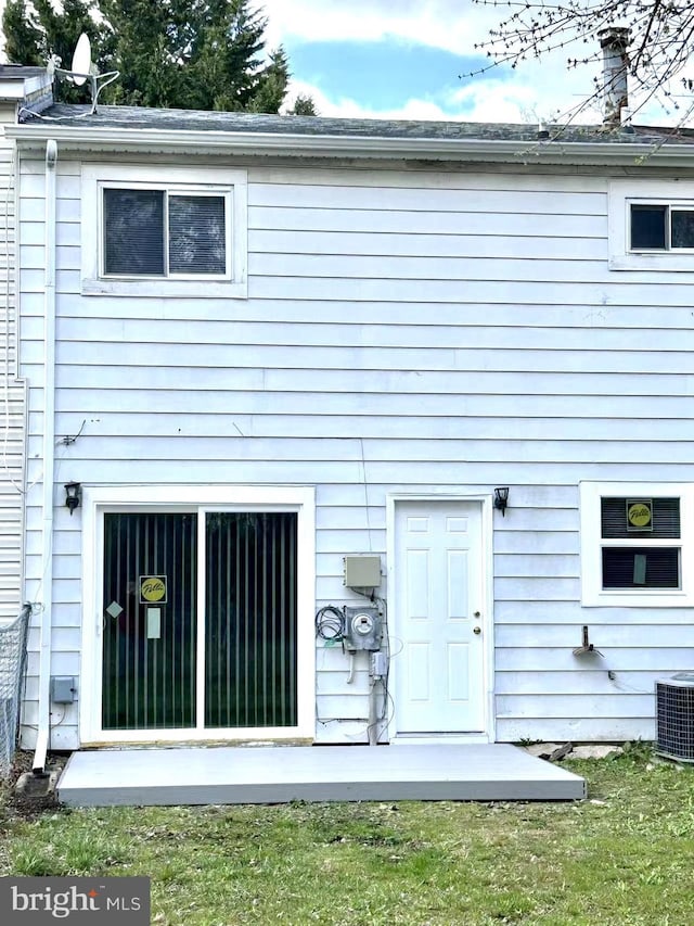 rear view of property featuring central AC unit