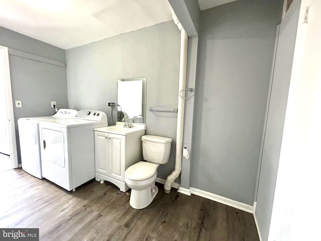 laundry room featuring a sink, wood finished floors, laundry area, baseboards, and washer and dryer