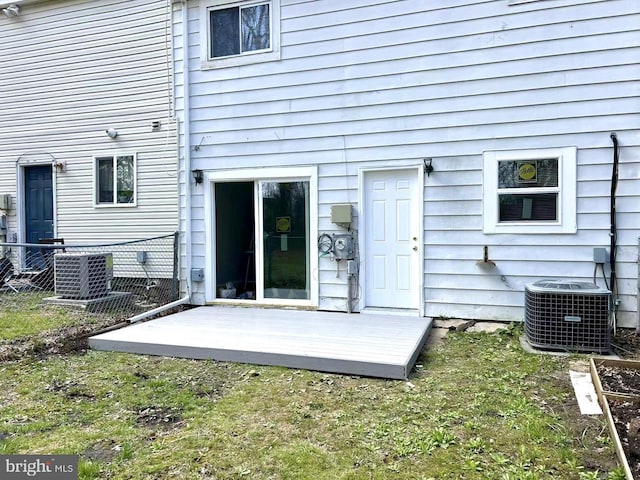 back of property featuring fence and central AC