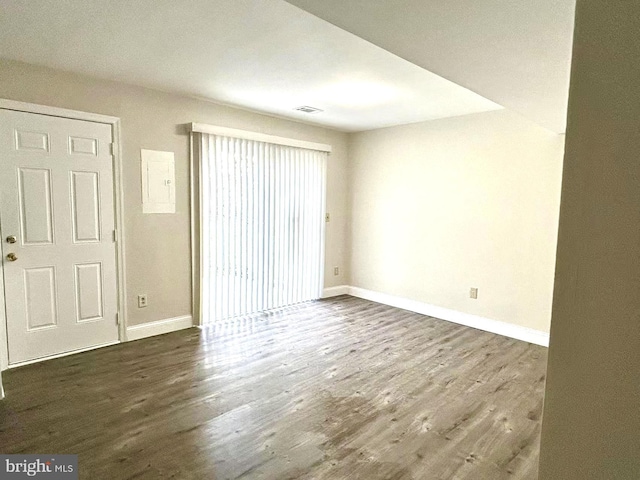 unfurnished room featuring baseboards, visible vents, and wood finished floors